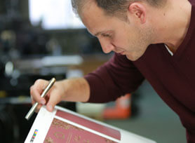 A proof is meticulously examined by a Giant designer before sending it to production for printing