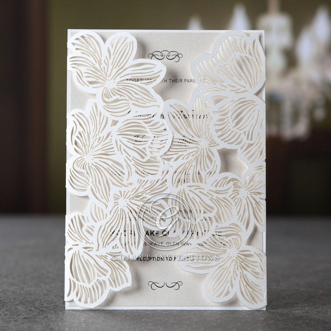 White gatefold invite with laser cut lotus flower design enclosing a pearlised inner card