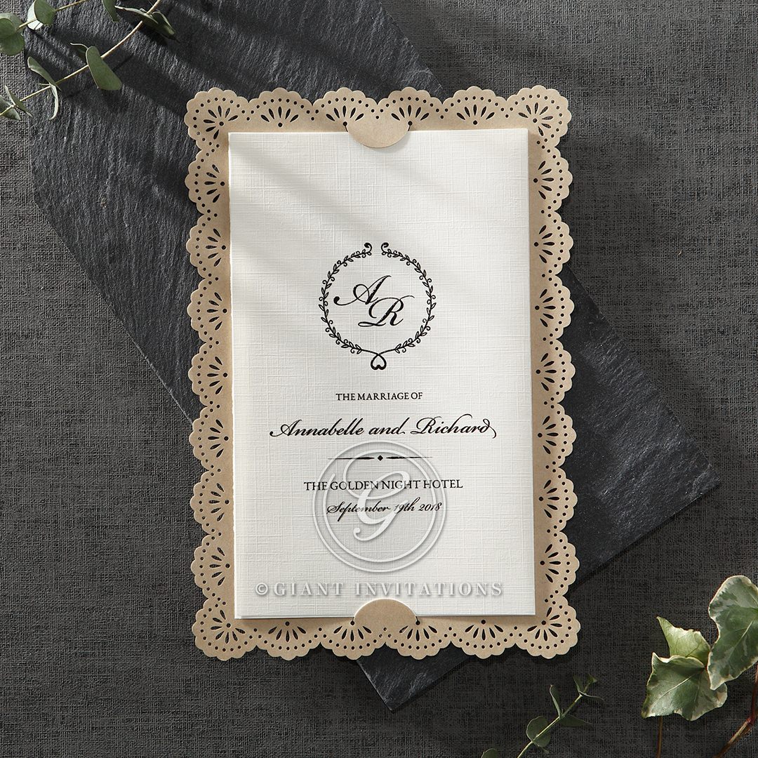 Lightly textured insert card in trifold design highlighting the coupleâ€™s initials, inserted in an organic brown backing card with die cut lace patterned border

