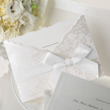 White satin lace with bow, wrapped around a pocket invite with silk screened floral pattern