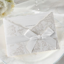 White bow and lace around a silk screened pocket invite with floral designs, smooth inner card stock