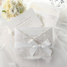 Smooth white card stock with embossed border, white floral pocket, with white satin ribbon