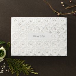 Trifold card with a whimsical embossed button patterned laser cut front cover, that opens to the main invite printed in raised letters
