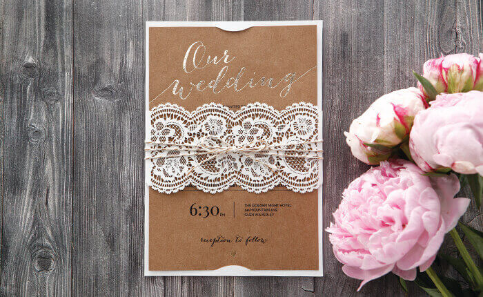 A foiled vintage country inspired invite with laser cut doily sleeve and twine